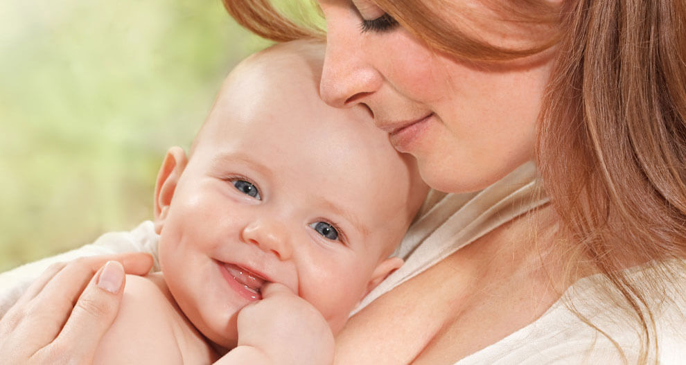 A woman lovingly holds a baby.