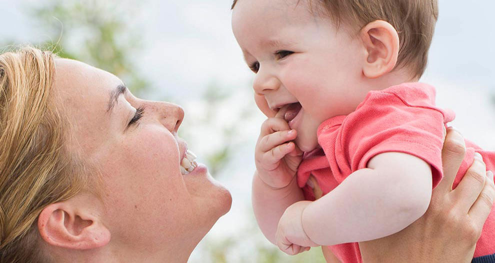 A woman and a baby are engaged in a close interaction.